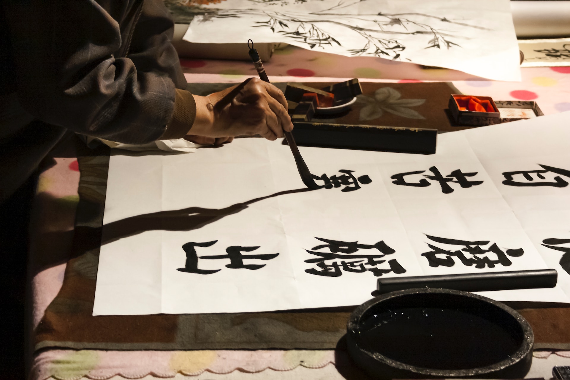 Man writing Chinese characters with a calligraphic brush