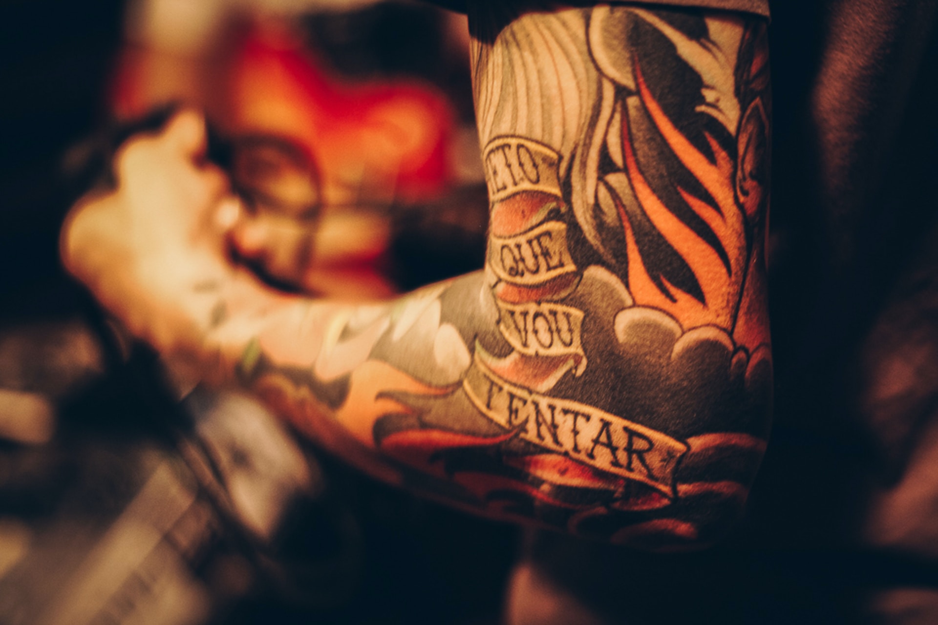 Tattooed arm of a man with big muscles in a dark environment