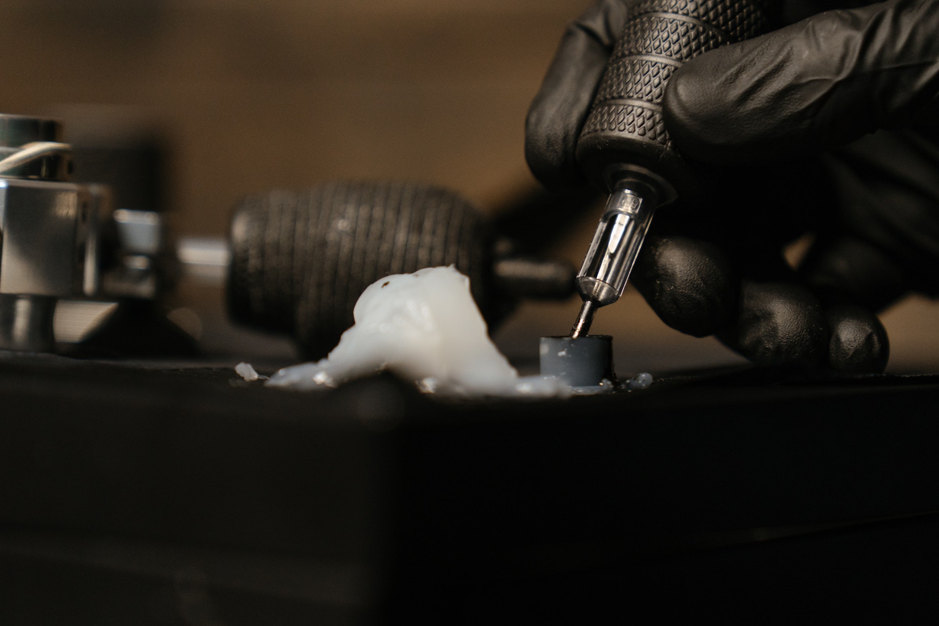 Person pouring tattoo ink on silver faucet