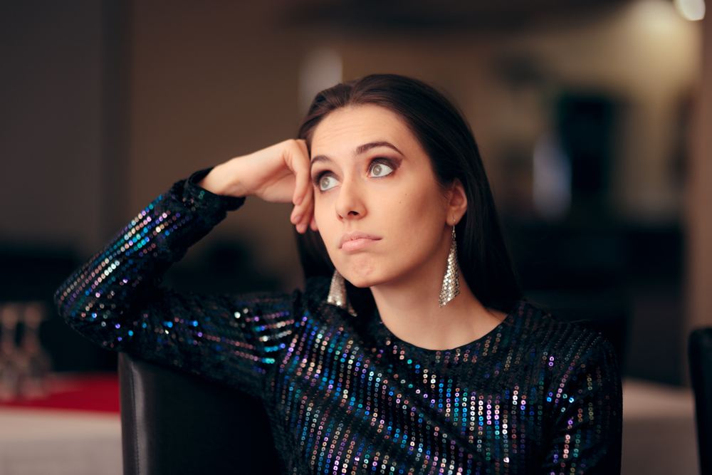 Upset girl feeling depressed attending a  wedding in sparkly dress