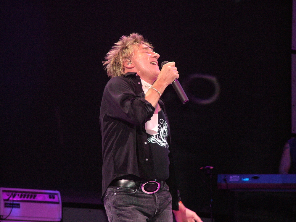 Rod Stewart performing on stage in black clothes