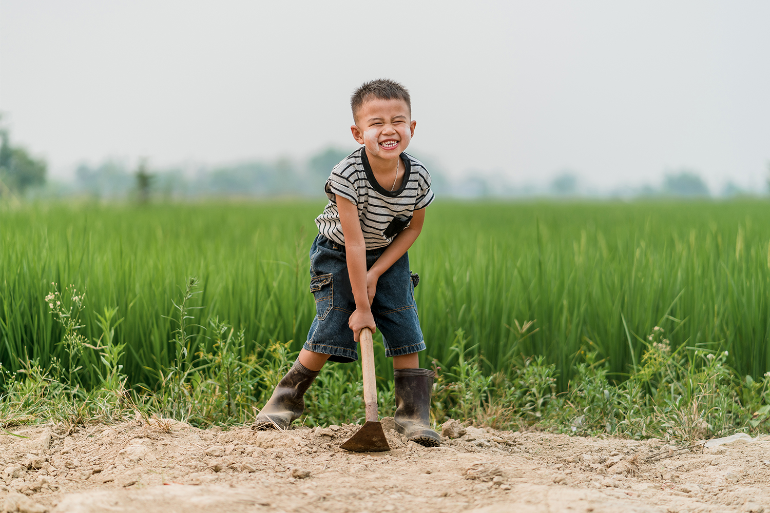 Kid Smiling And Holding A Shovel