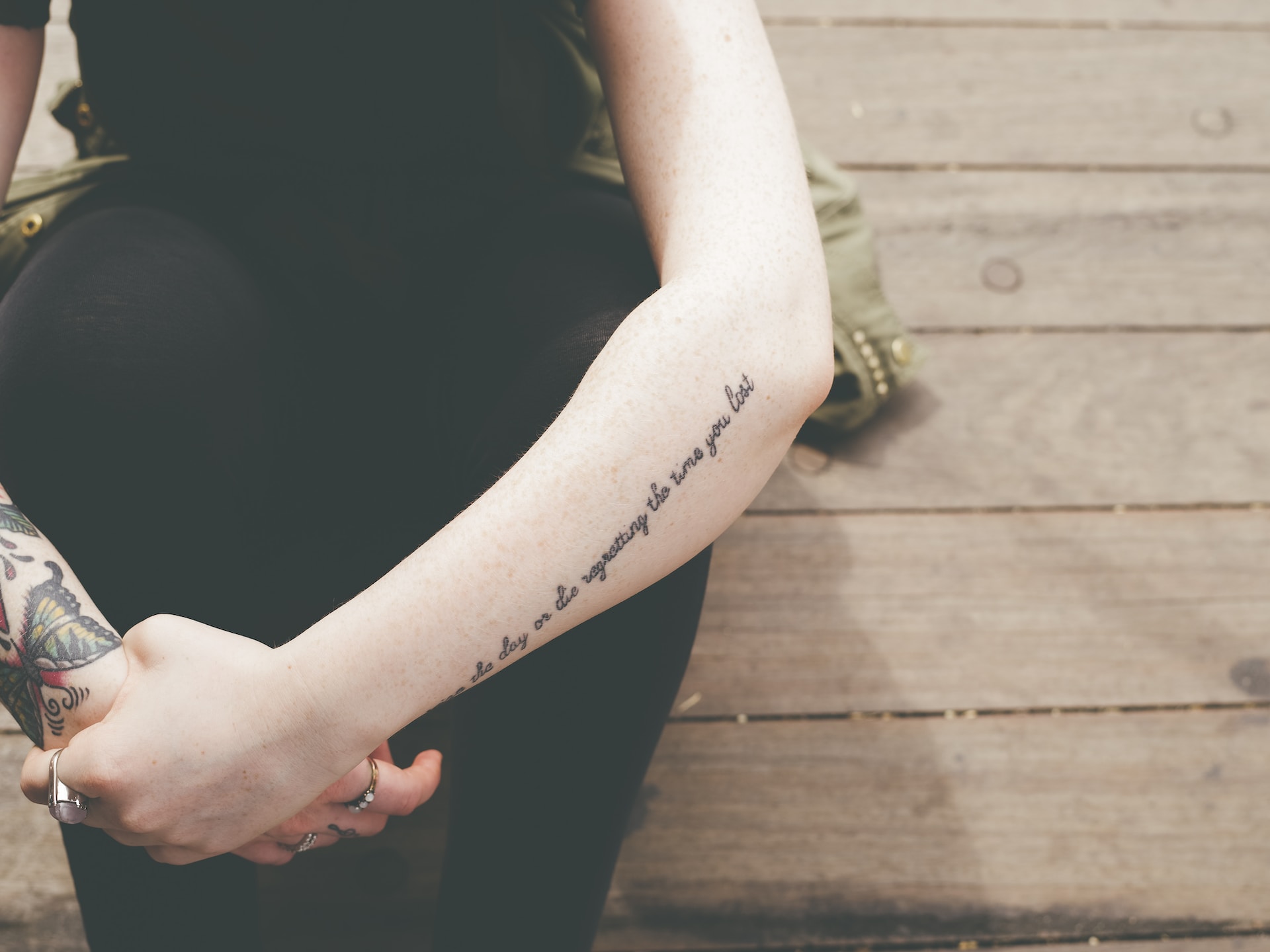 Woman with a lyrics tattoo on her left arm