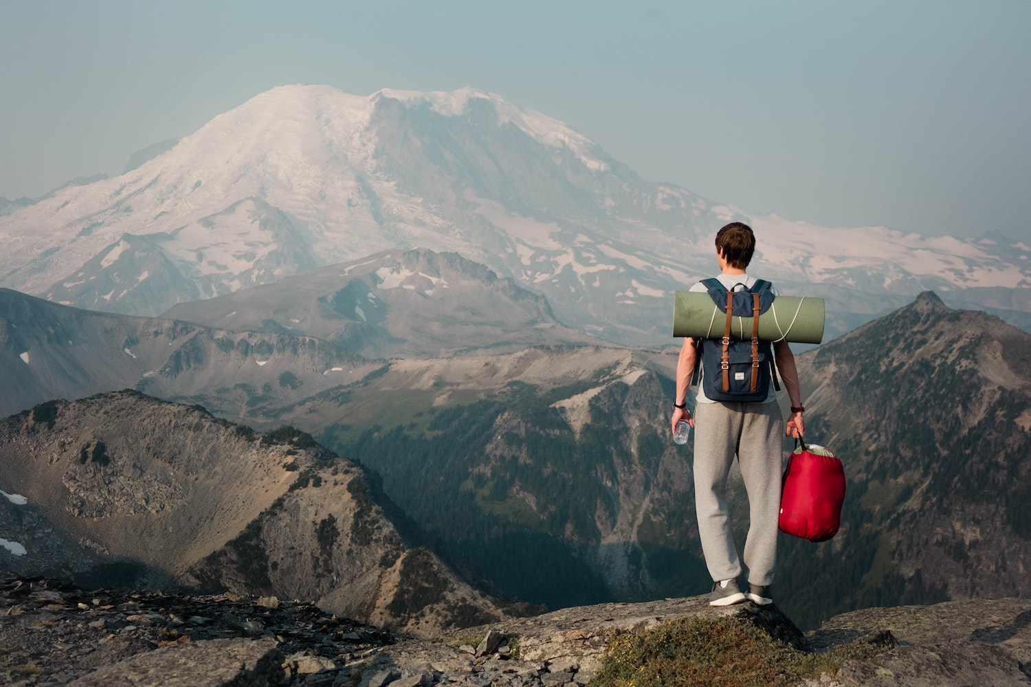 Unrecognizable backpacker standing on top of mountain