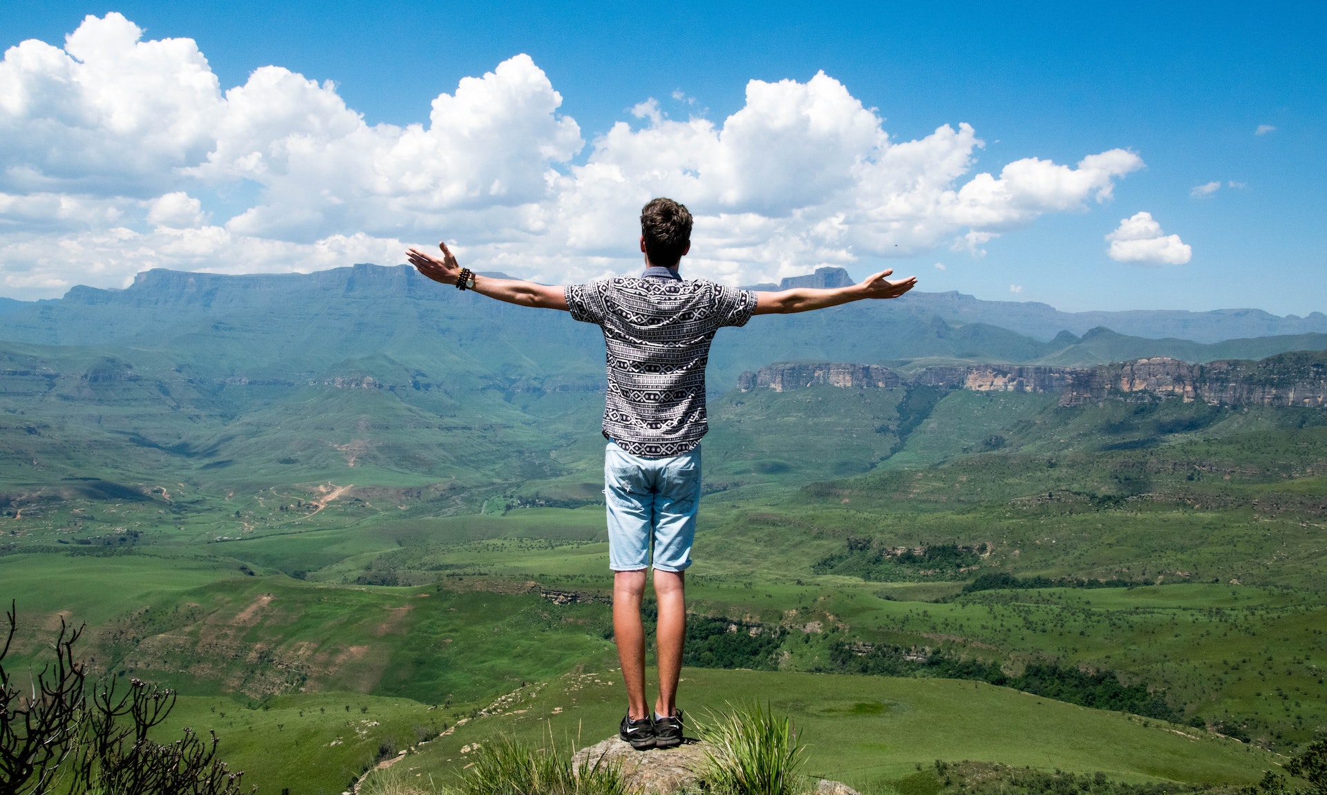 man standing on elevated surface looking at nature