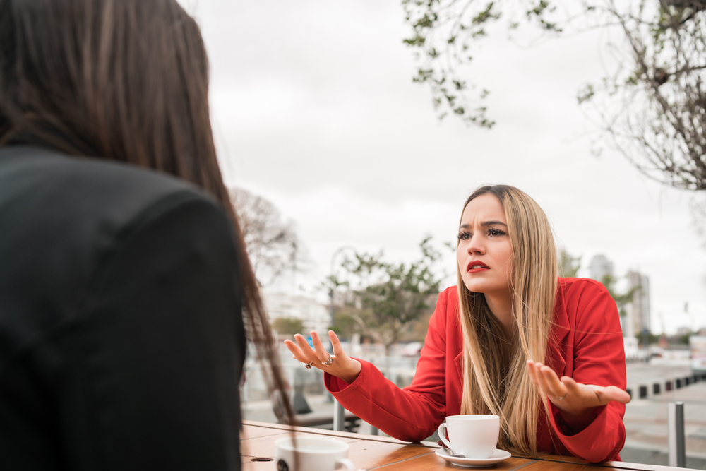 two angry friends having a serious conversation at coffee shop