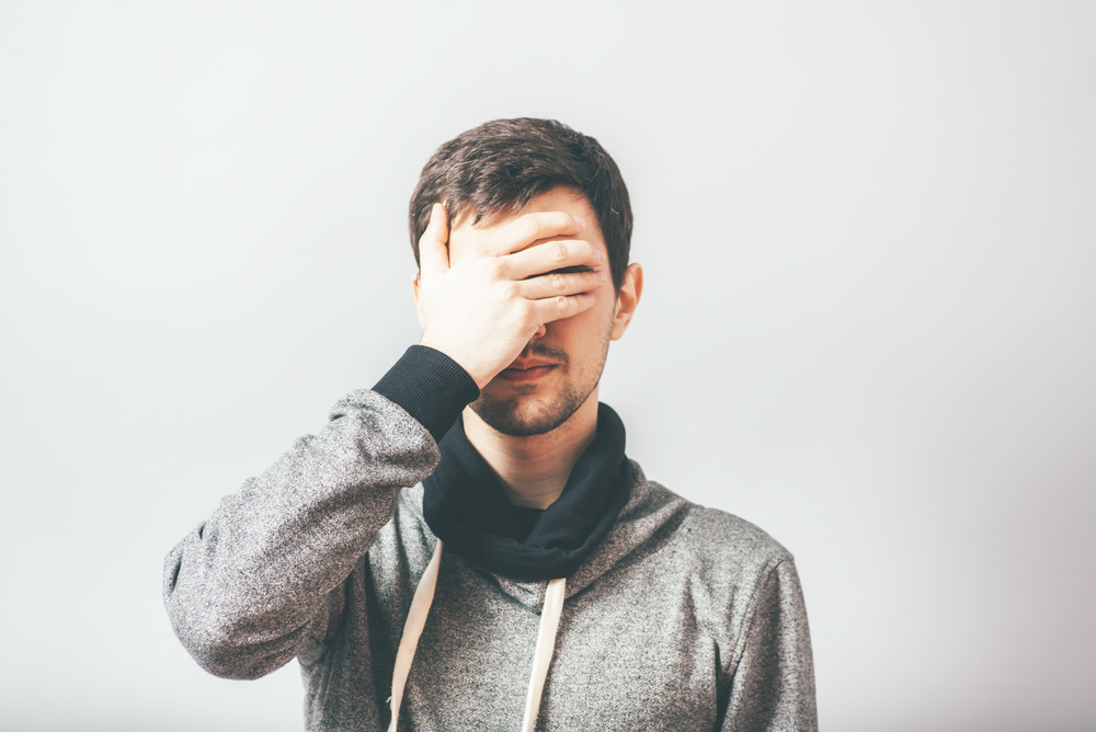 man closes his eyes with his hands