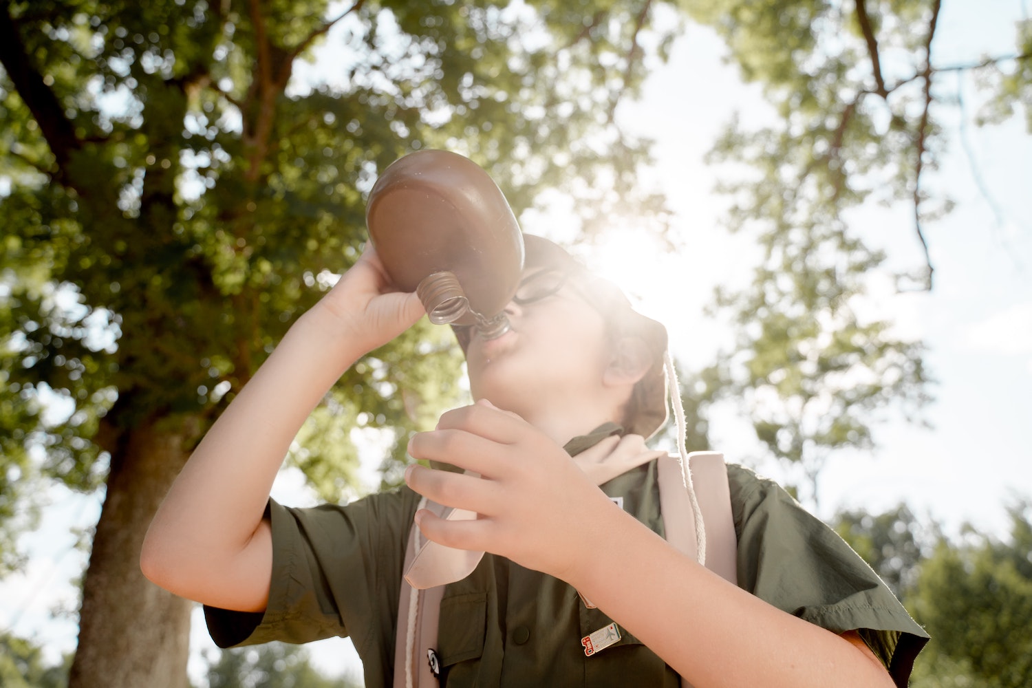 A Boy Scout Drinking from a Flask