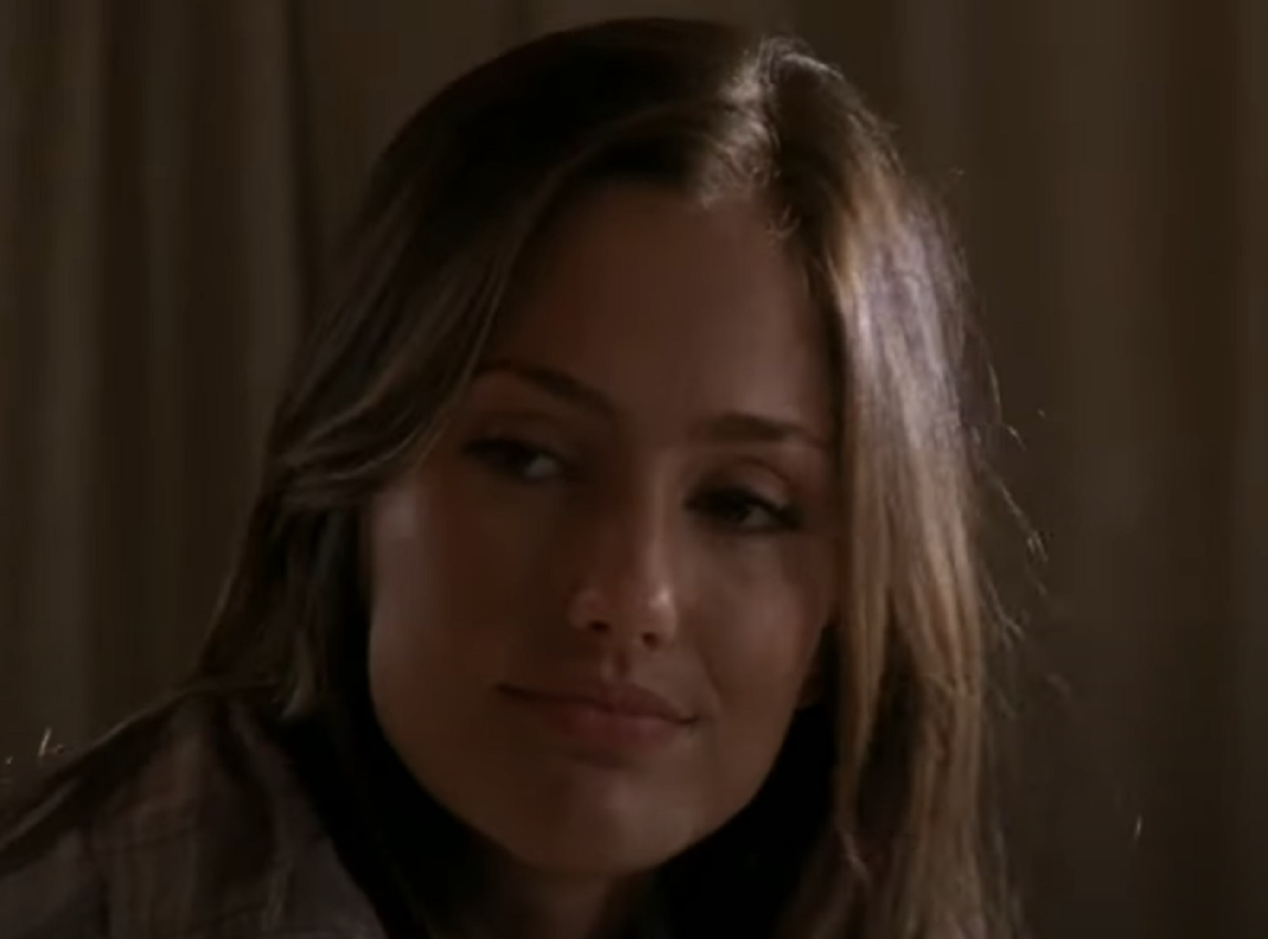 Screenshot: Minka Kelly wearing grey shirt is looking at side and smiling - from Friday Night Lights (2006-11)