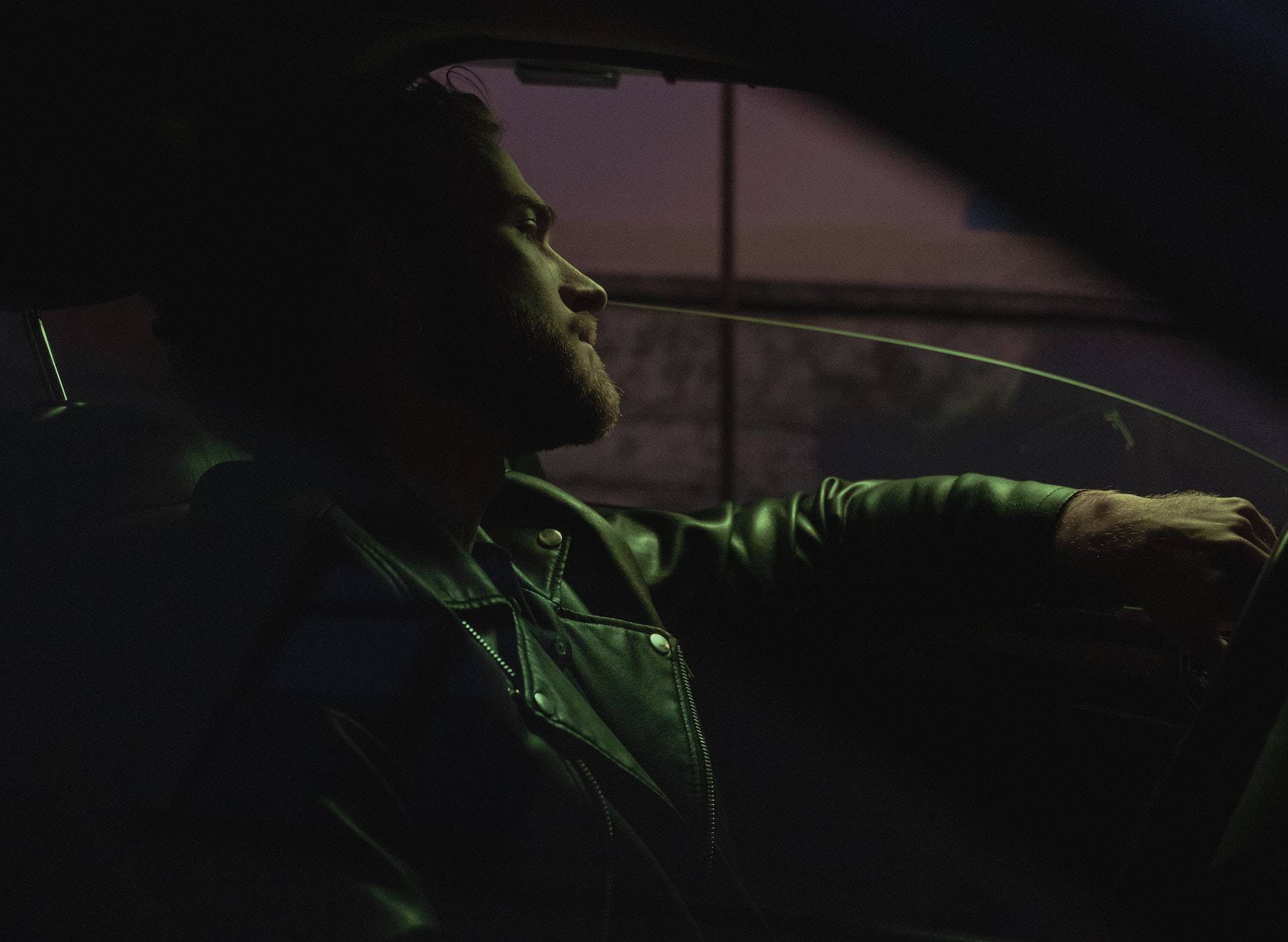 Man sitting in car at night