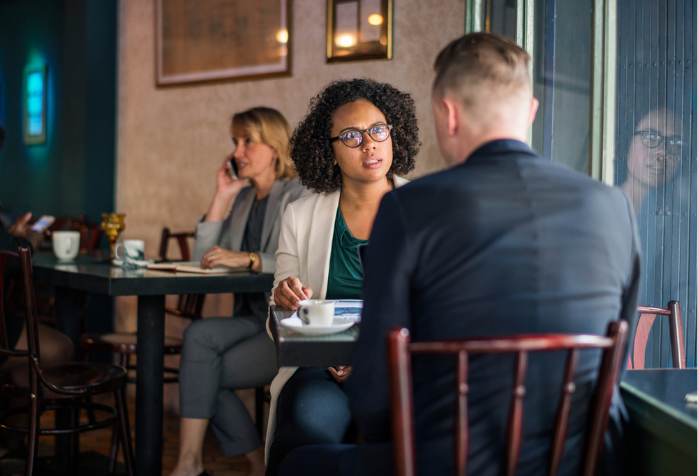 Shocked Woman on a bad date in café sitting at the table