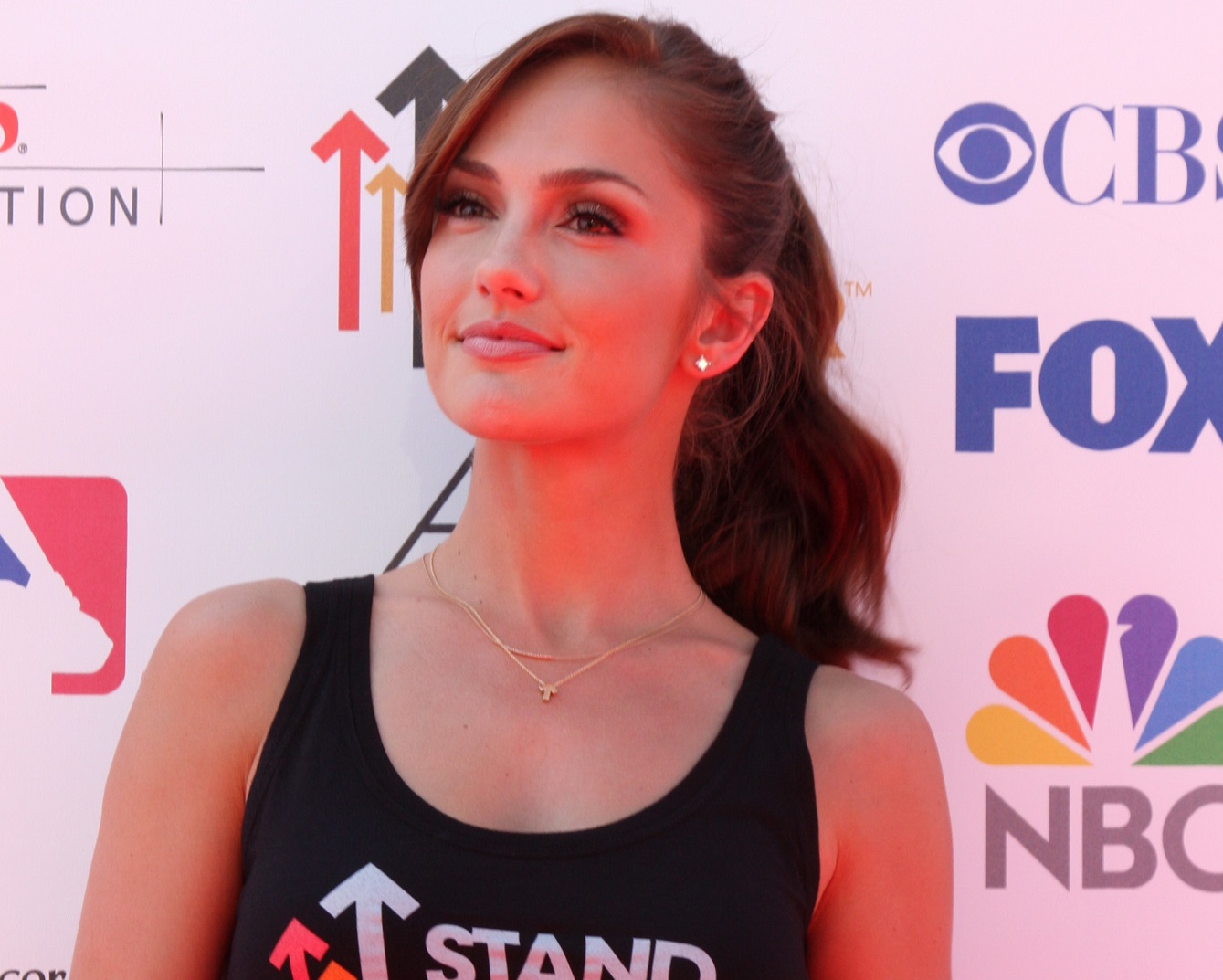 Minka Kelly wearing black shirt is looking at side and smiling - 2012