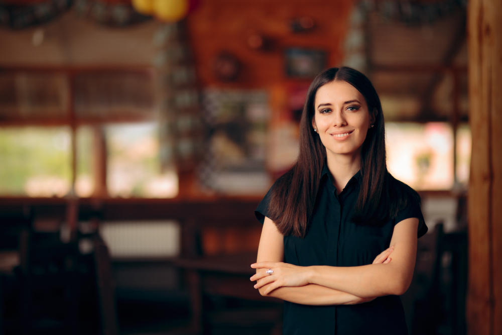 Hostess Standing in a Restaurant Welcoming Customers
