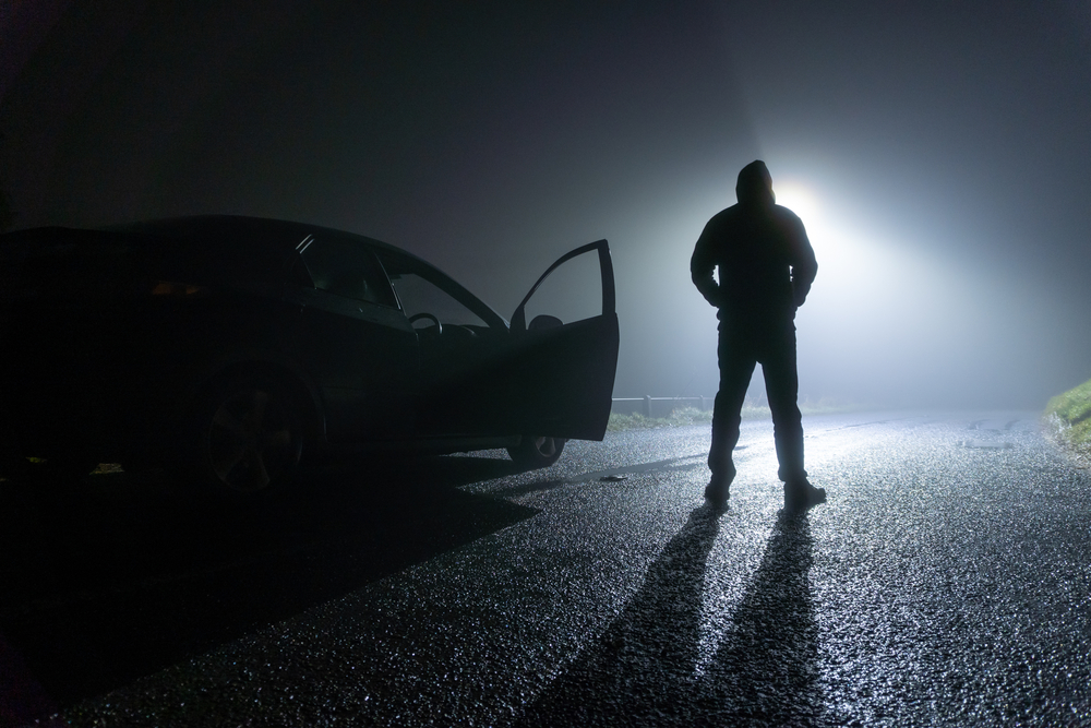 man standing next to a car, with door open