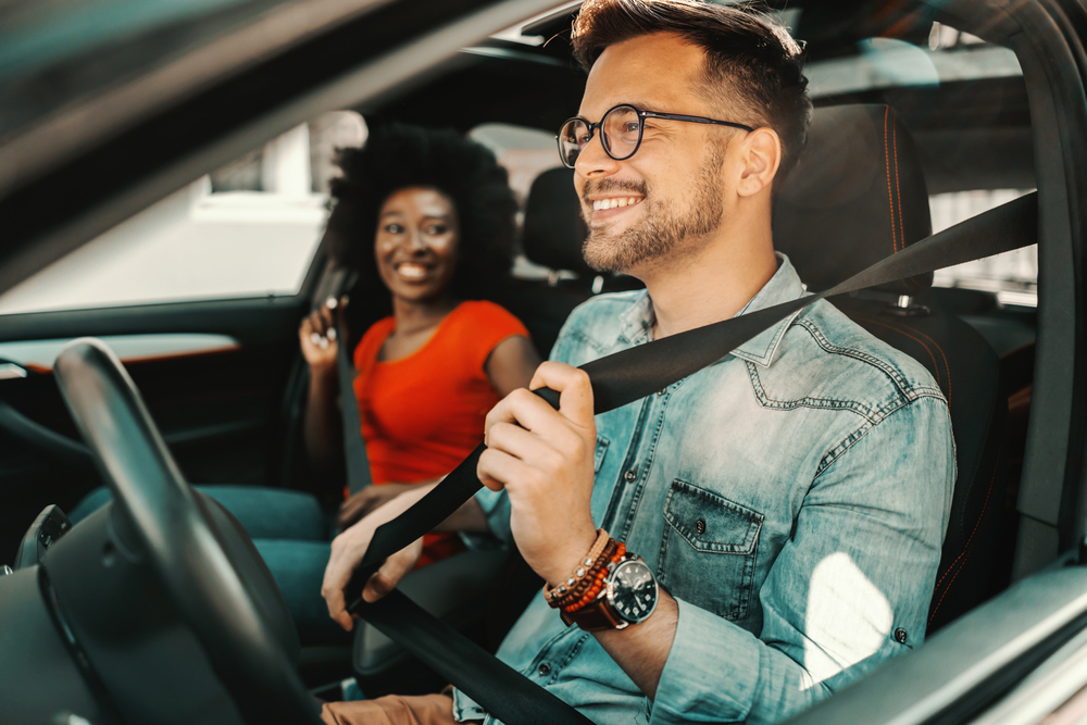 Young multiracial couple sitting in a car