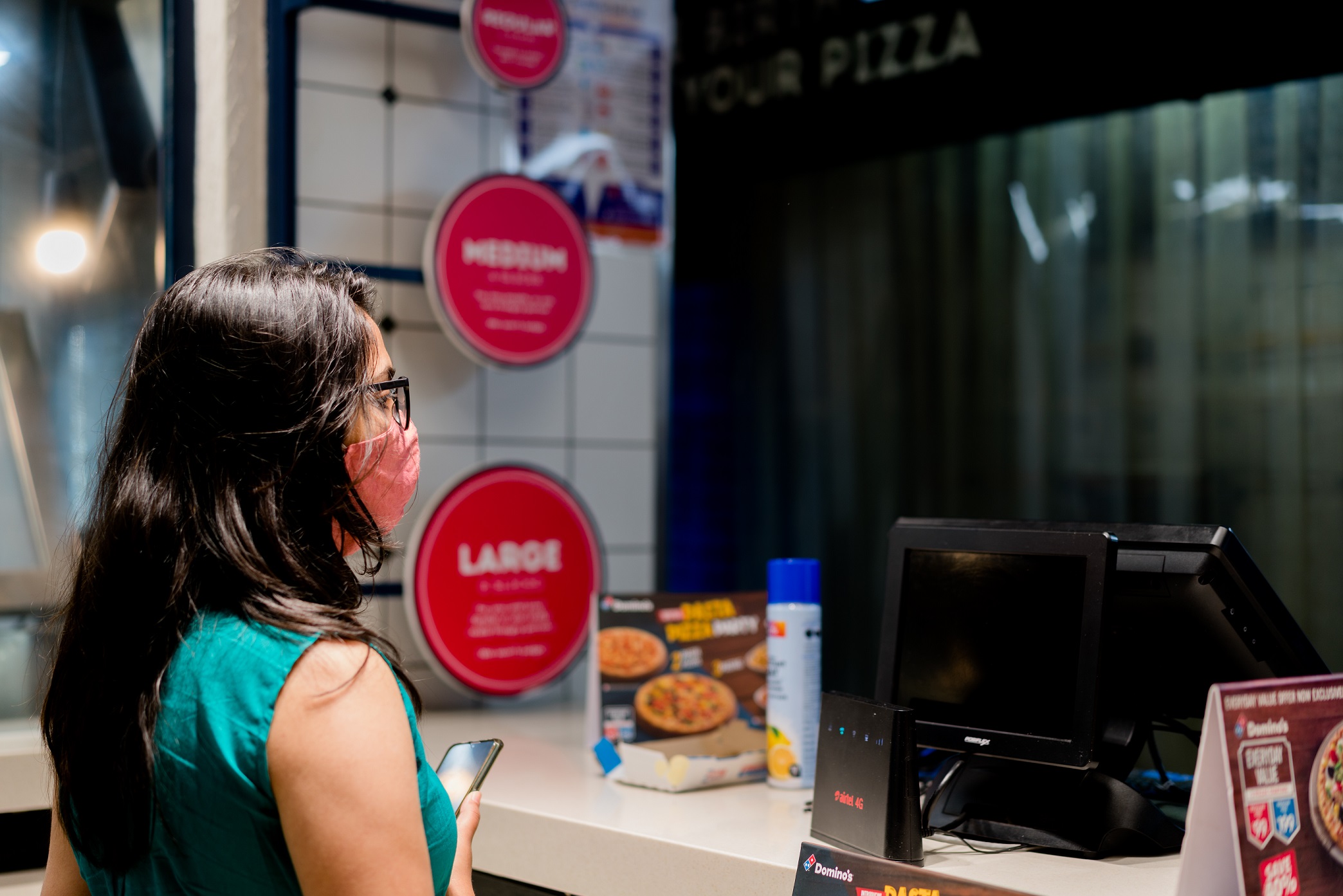 Woman is ordering at a Domino's pizza.