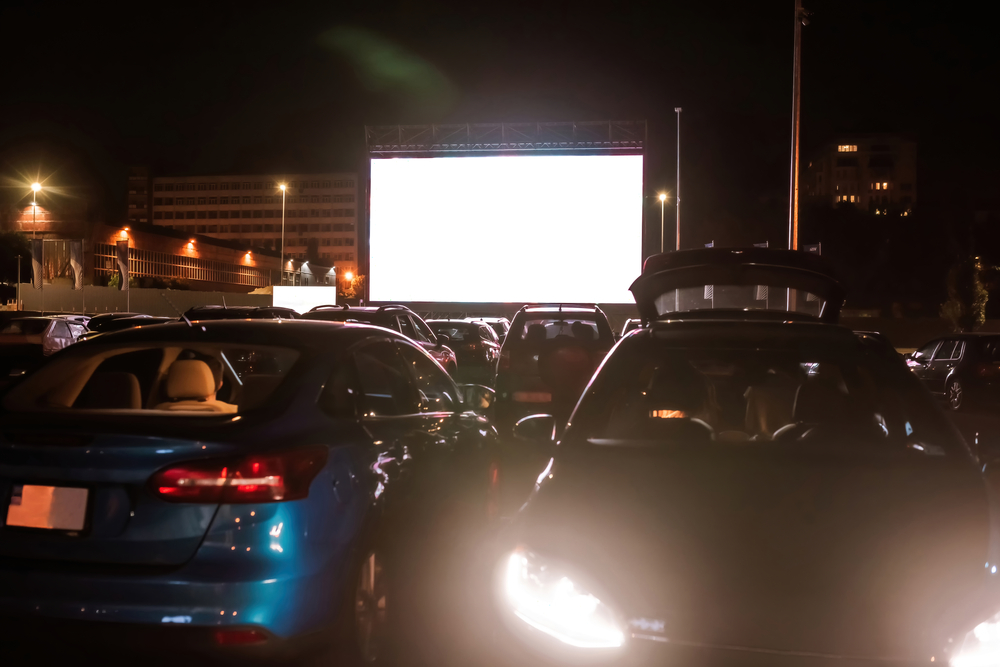 sitting inside a car at drive in cinema in the evening