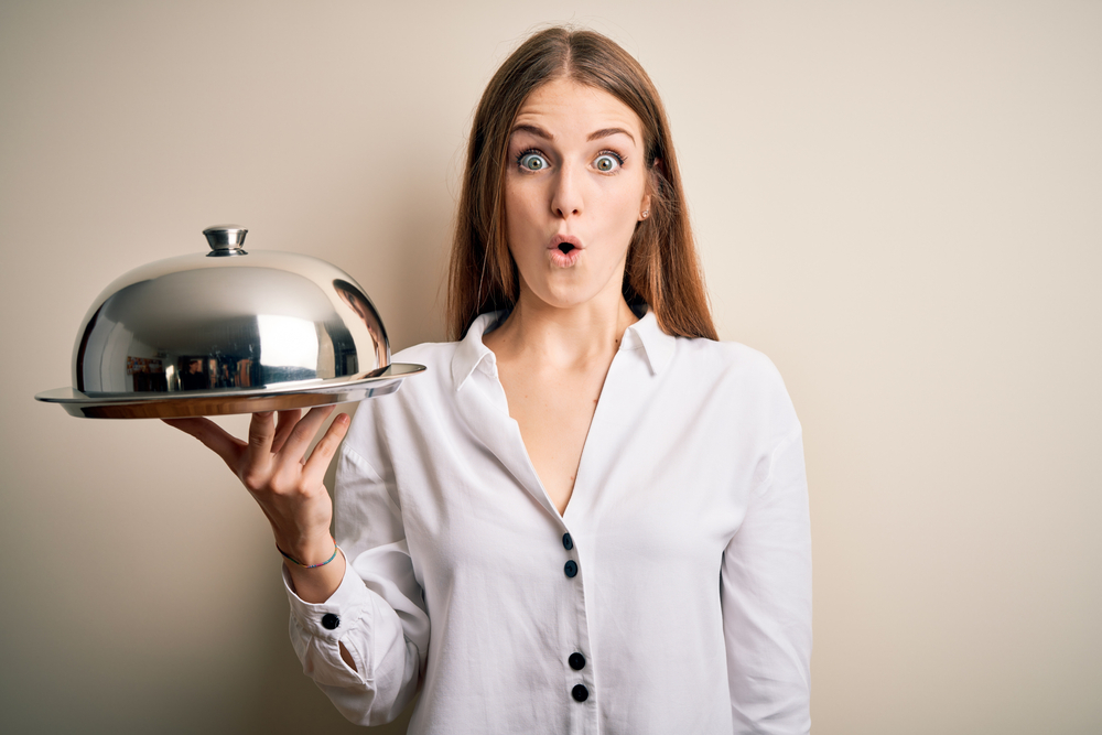 woman holding waitress tray  with a surprised face