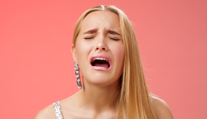 Sad girl in silver dress crying at her birthday party