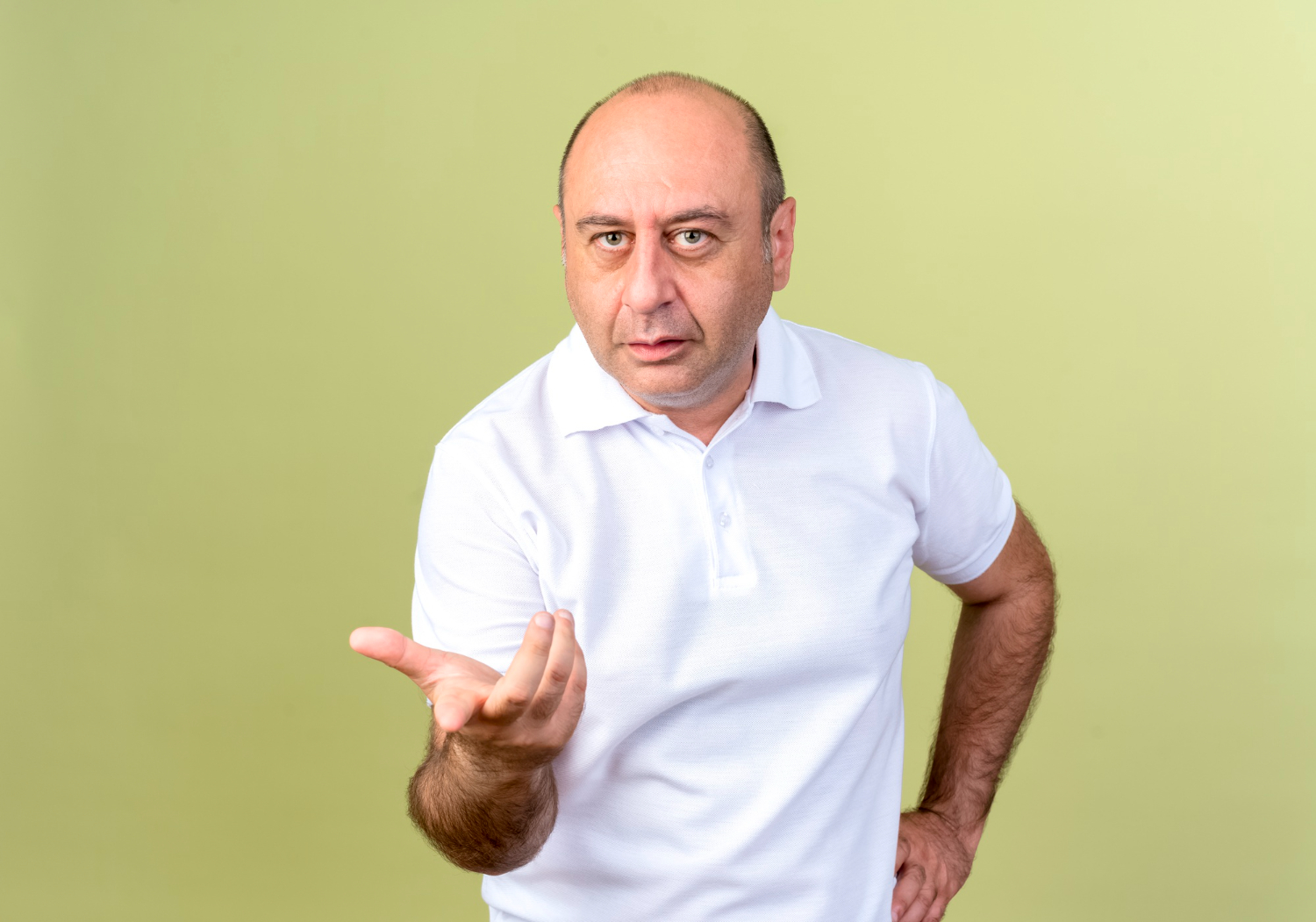 Confused mature man points at and putting hand on hip.