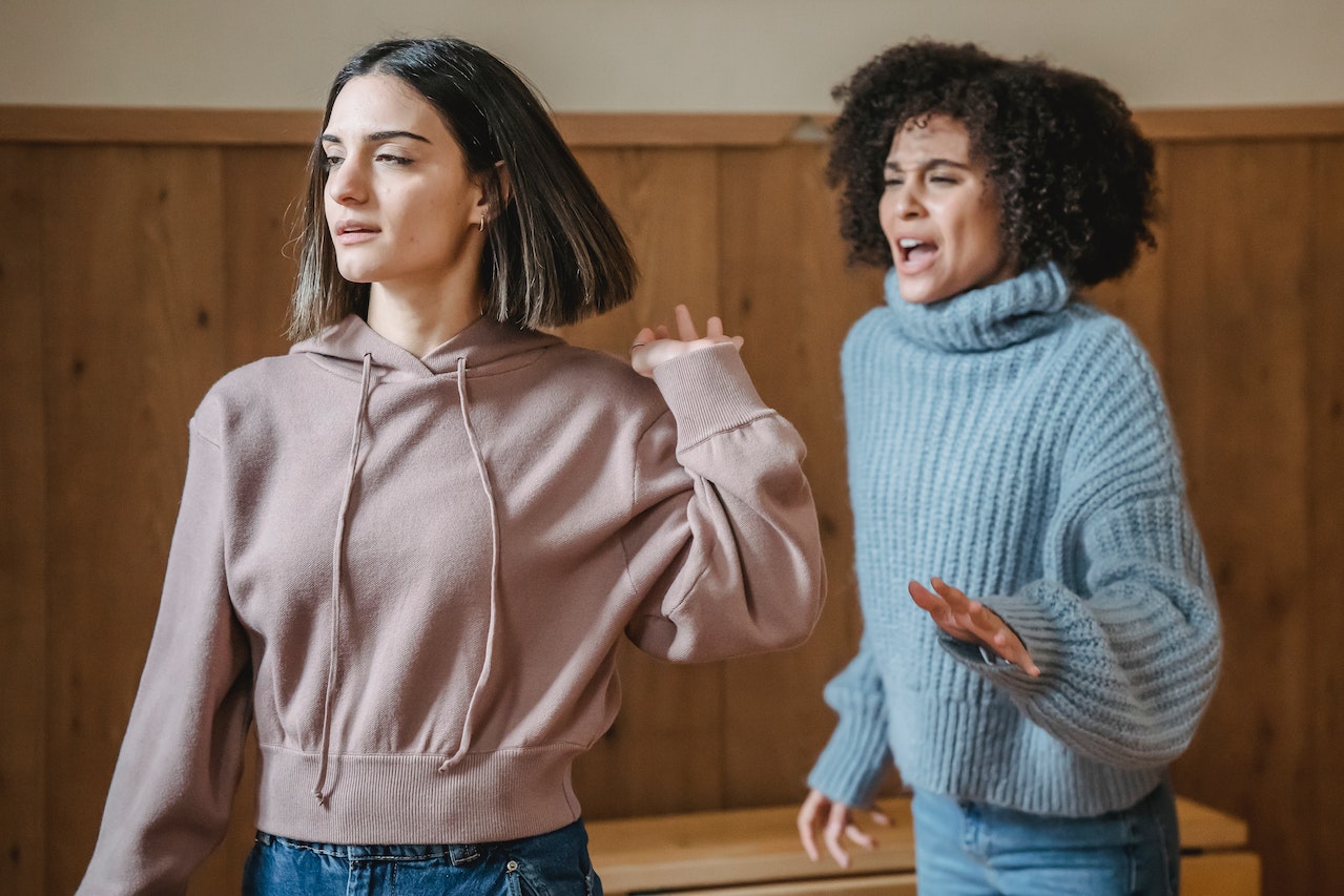 Two young woman are arguing about something.