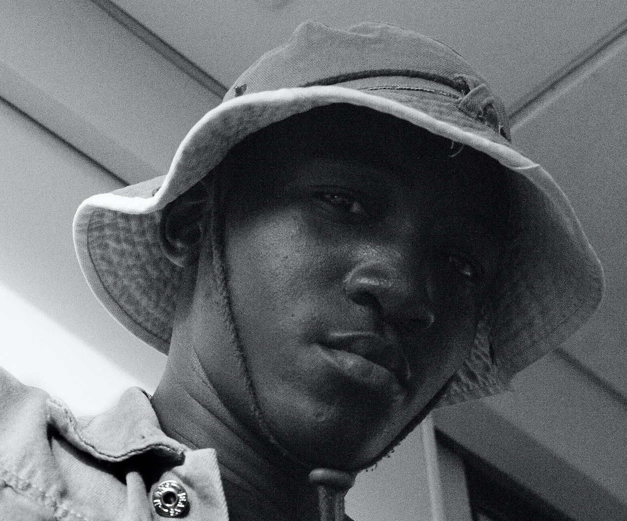 Black man is wearing safari hat and looking at camera.