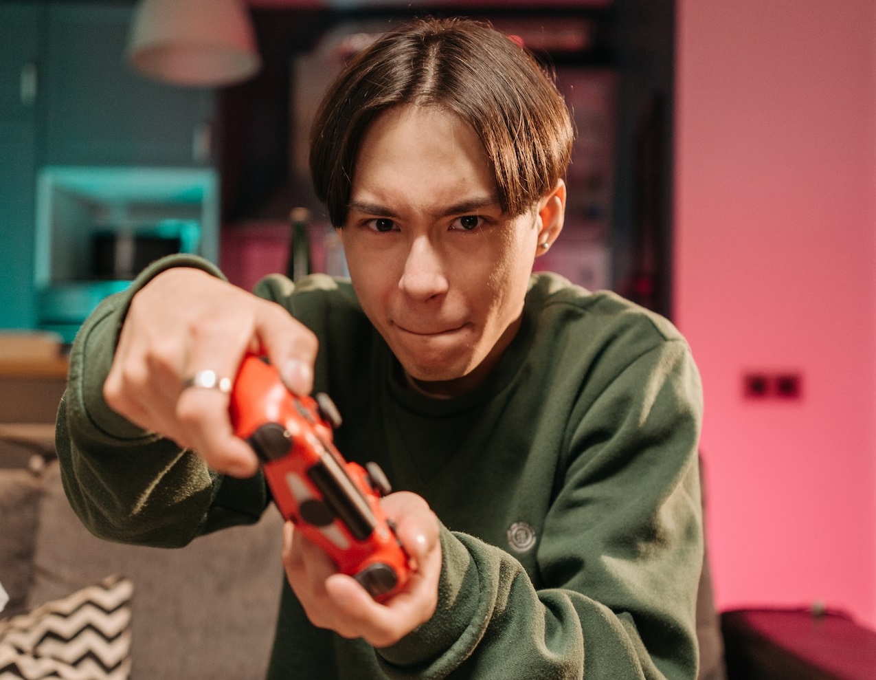 Upset young man is holding a PS controller.