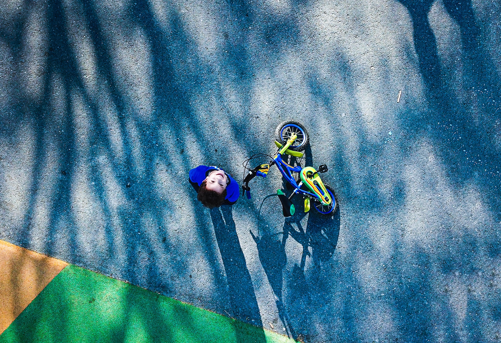 top view photo of kid near bicycle