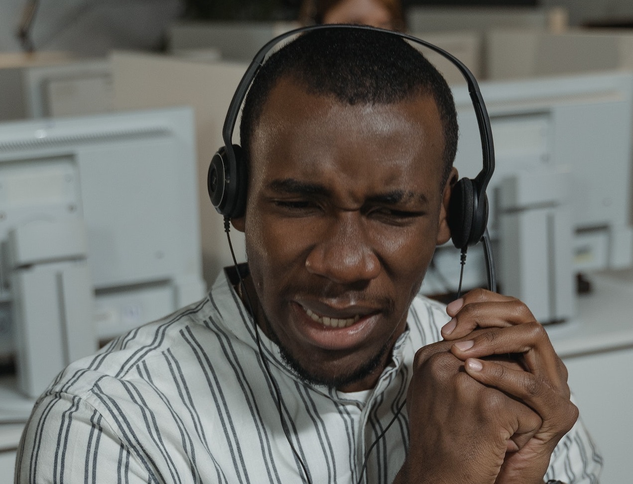 Man wearing headphone set is talking on the phone with surprised face.