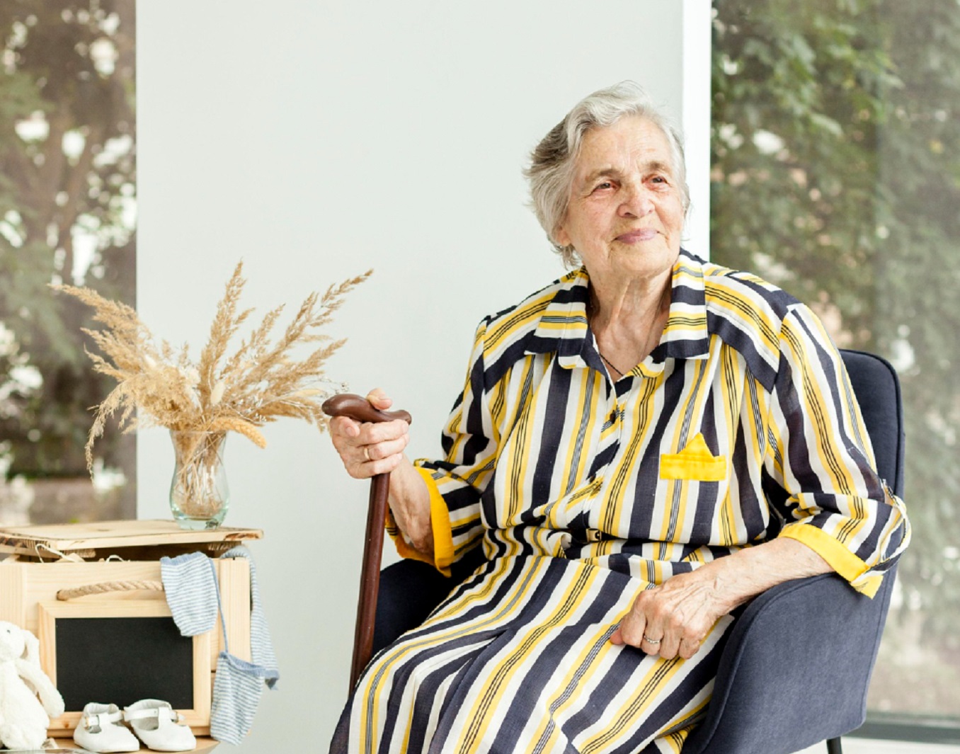 Senior woman is seating and looking at side.