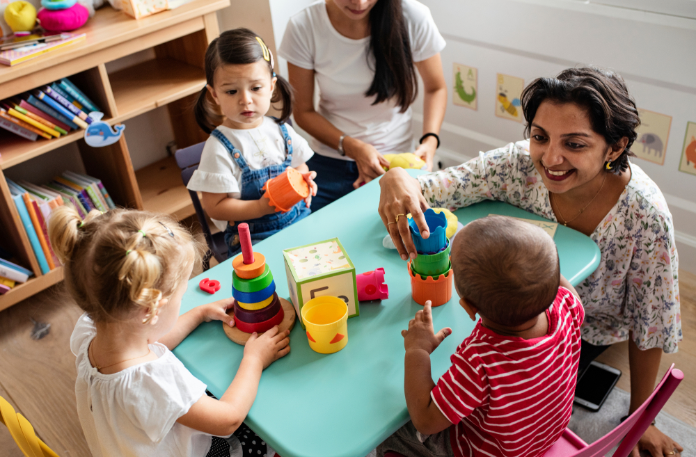 Nursery children playing with teacher