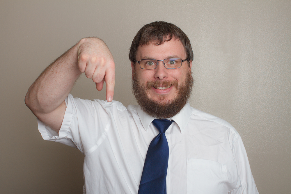 Man pointing down with his finger with a creepy smile on his face