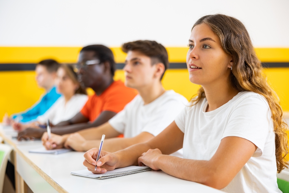 Students in school sitting at desks writing