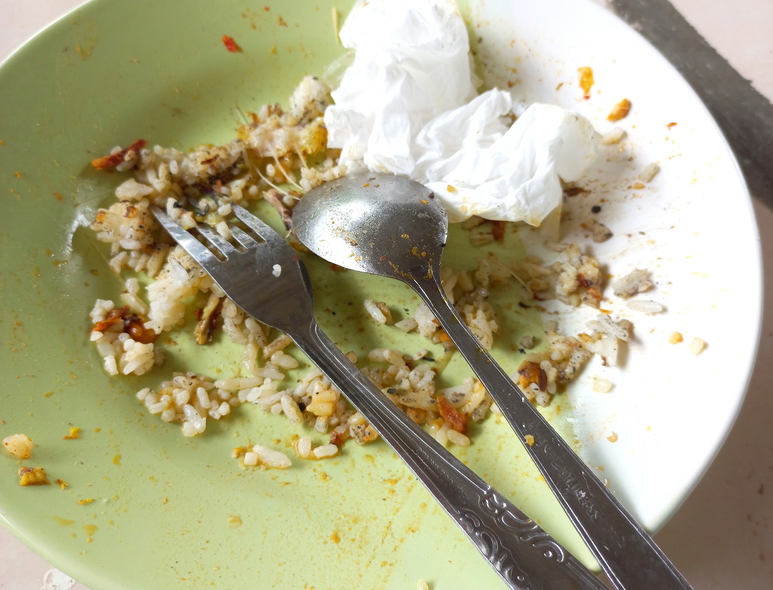 Dirty plate with leftover food on floor.
