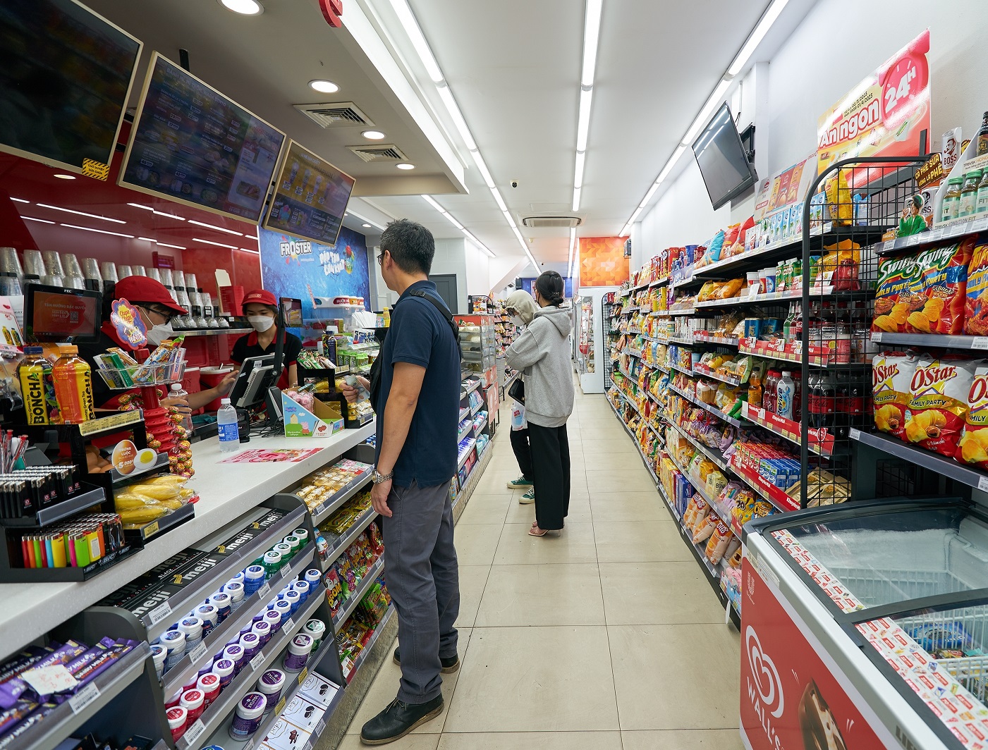 Interior shot of convenience store with employees and costumers.