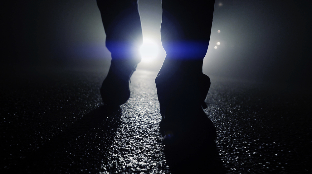 silhouette of feet walking on street at dark night