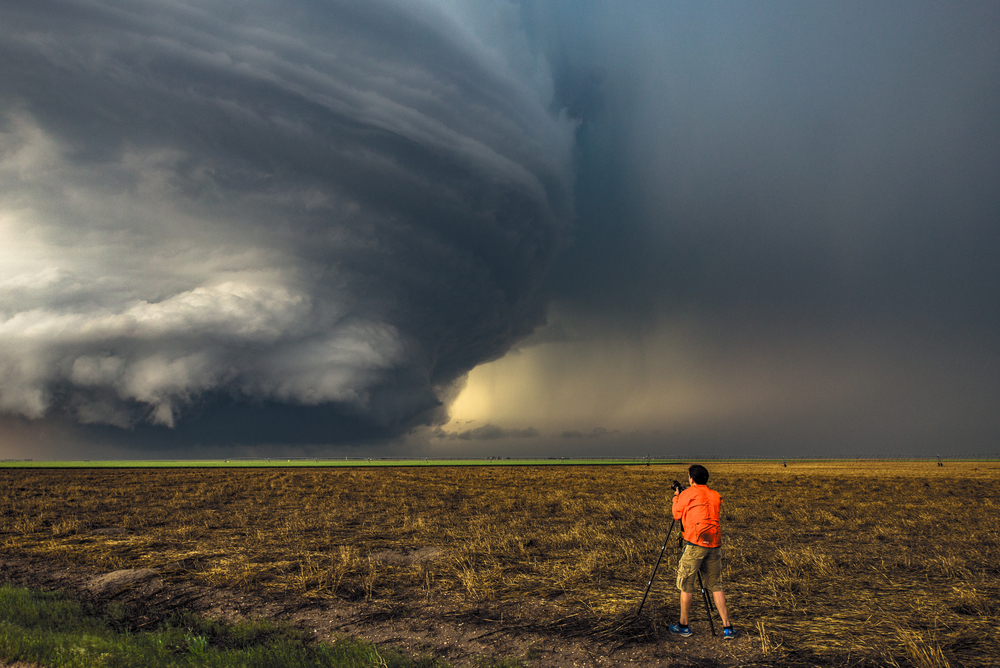 Man in orange shirt chasing  storms