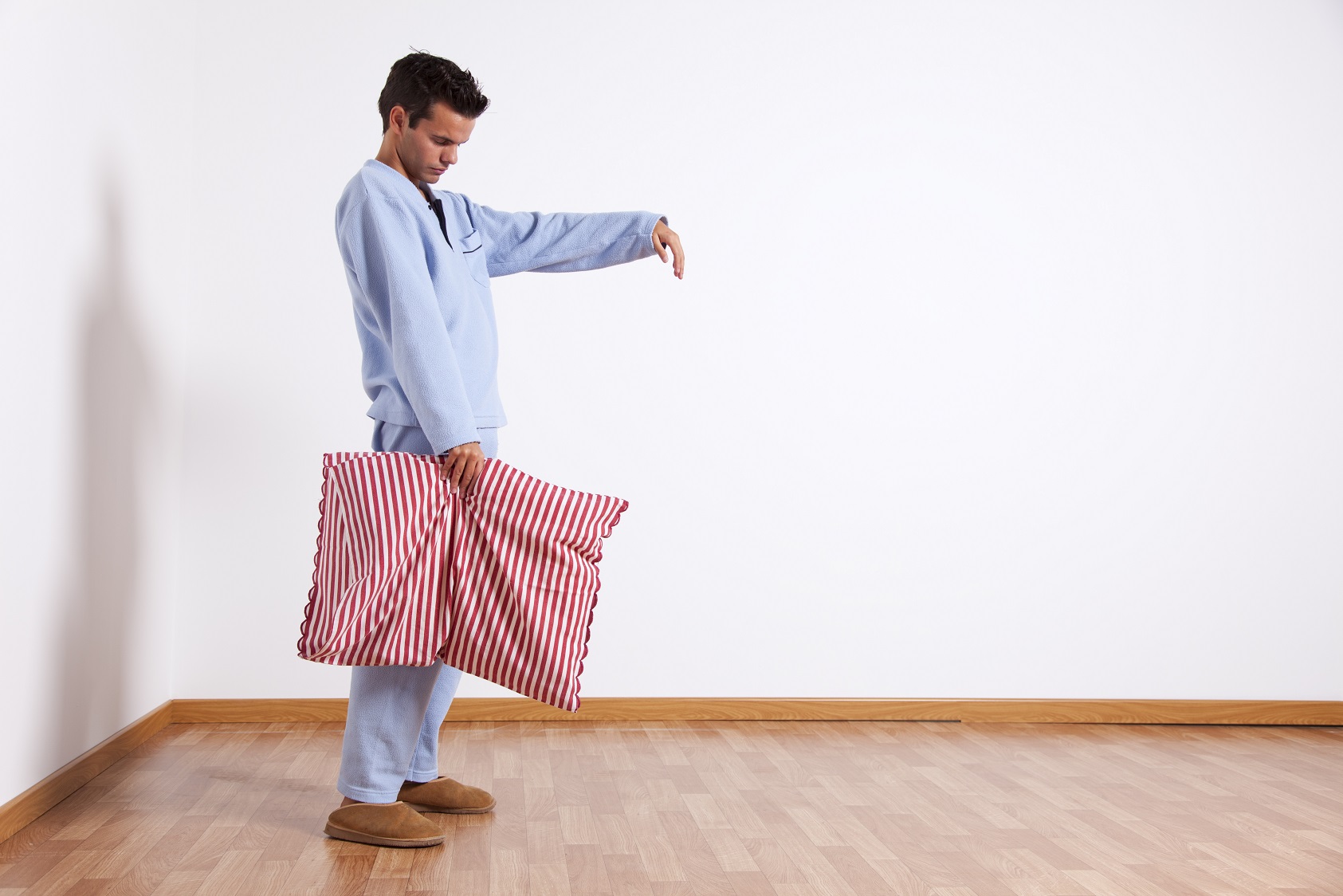 Young man sleepwalking at his home dress with blue pajamas.