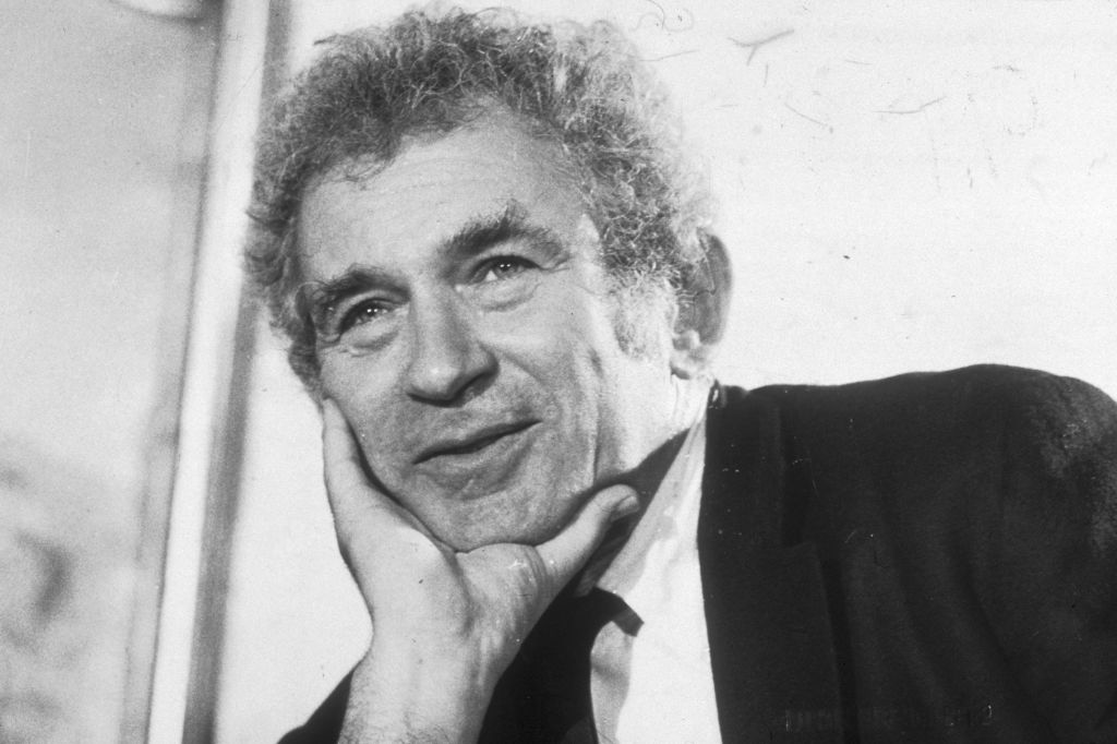 American author Norman Mailer smiling during a press conference