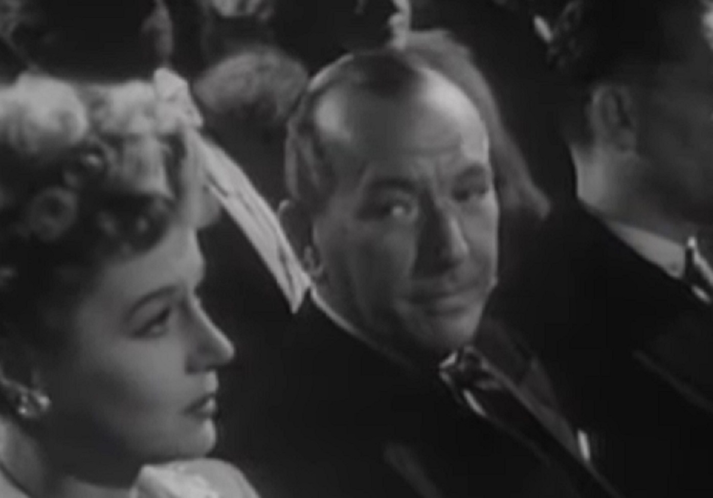 B&W Screenshot: Noel Coward is seating and looking to female - from Mad About the Boy: The Noel Coward Story (2023)