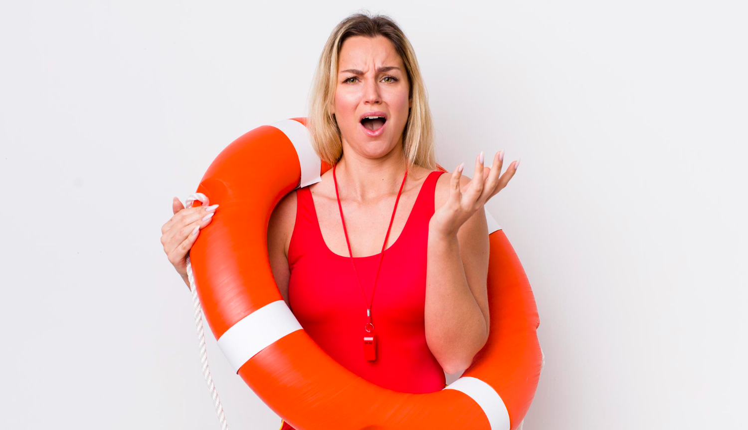 Shocked female lifeguard wearing red suit is looking at camera.