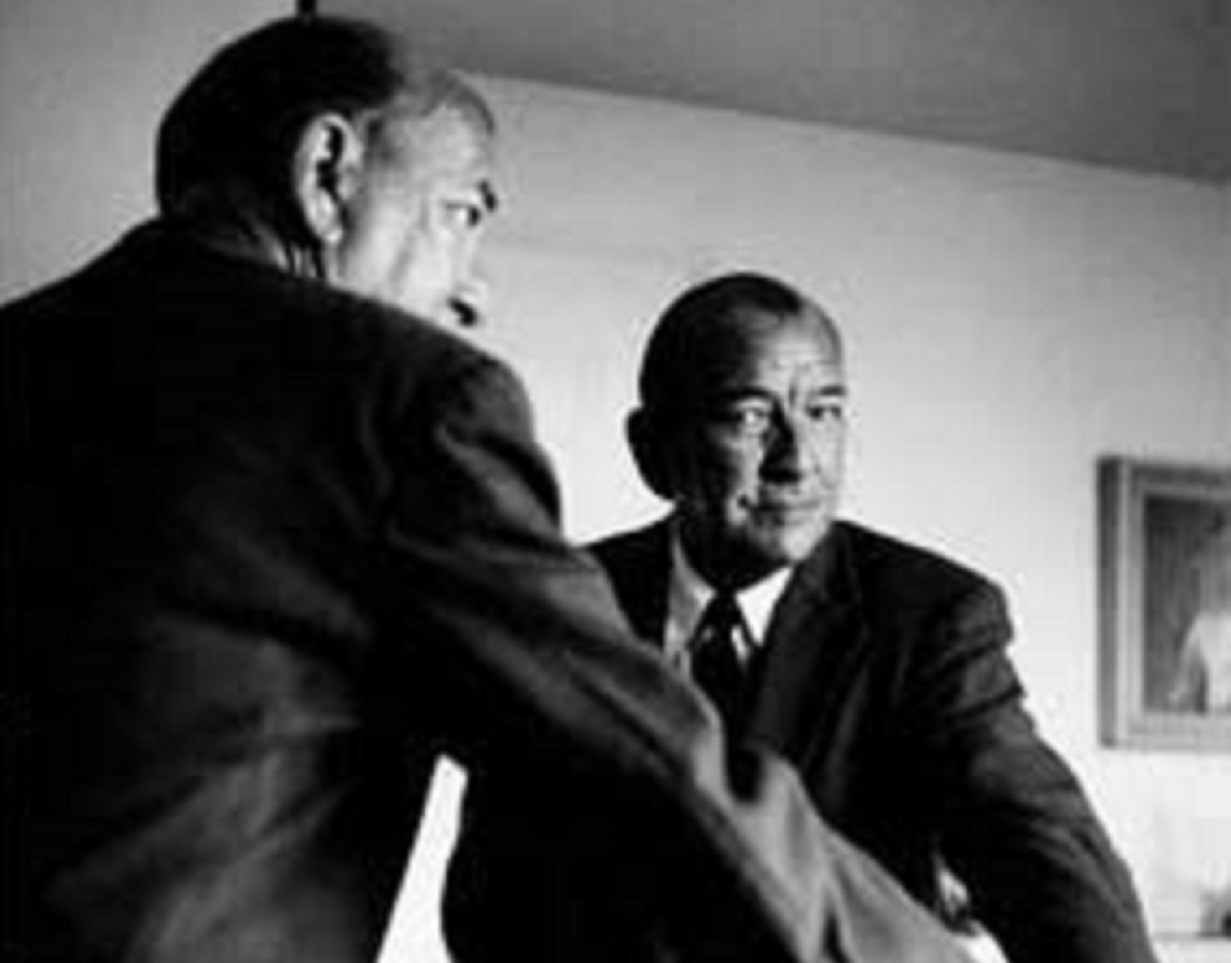 B&W photo of Noel Coward wearing black suit is looking back from the mirror - 1963