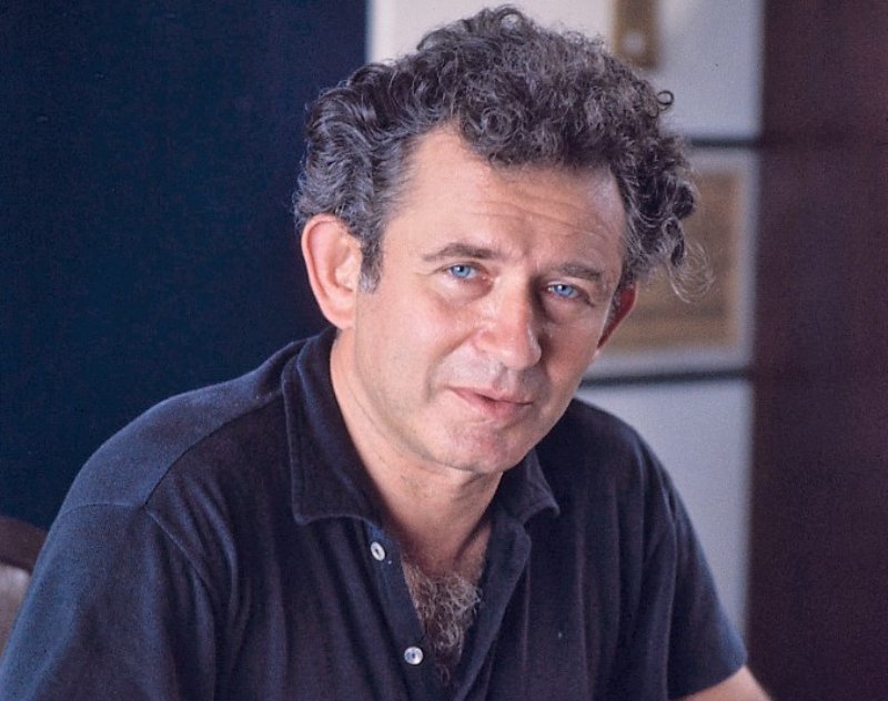 Norman Mailer, writer sitting at a desk looking at the camera