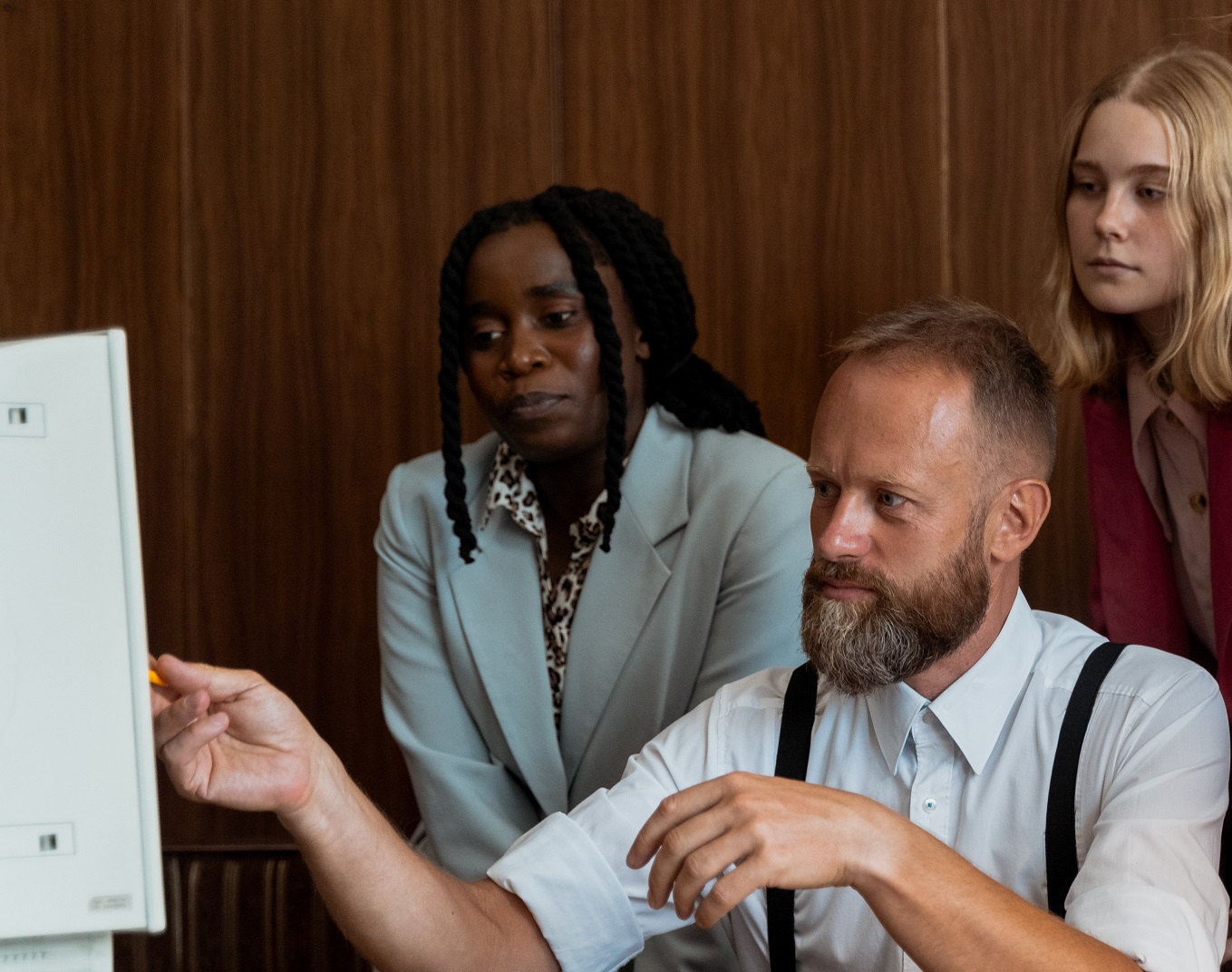People at office having a meeting and looking at PC.