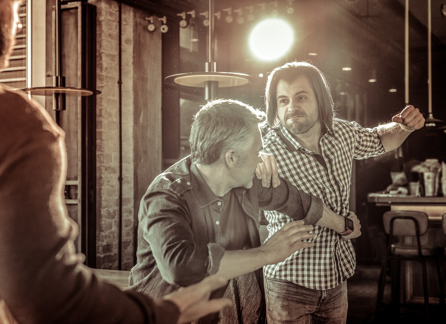 Angry males being drunk and going to fight at bar.