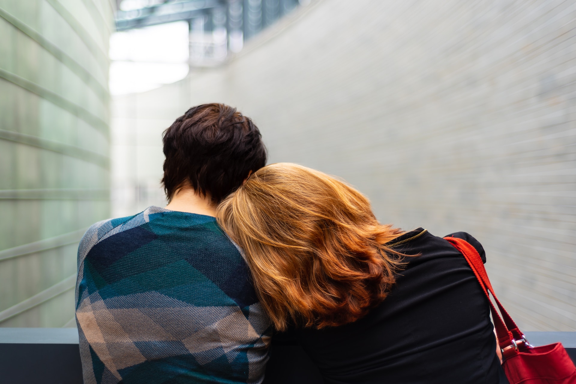 child leaning on woman's shoulder