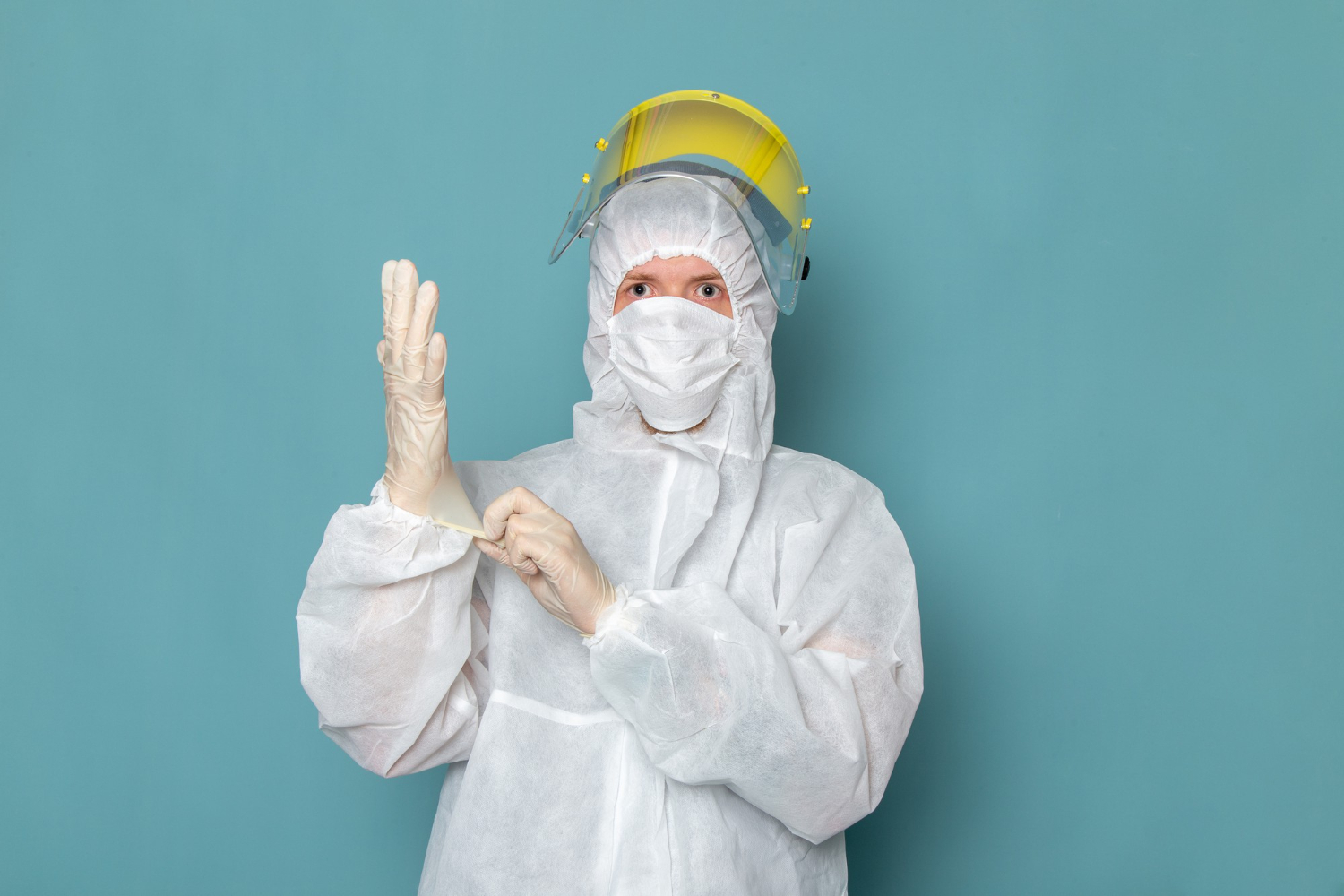 Male in special suit and yellow special helmet wearing white gloves is looking at camera.