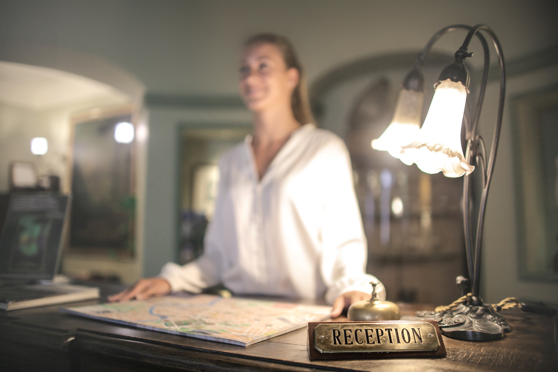 Employee at front desk of a hotel welcoming guests