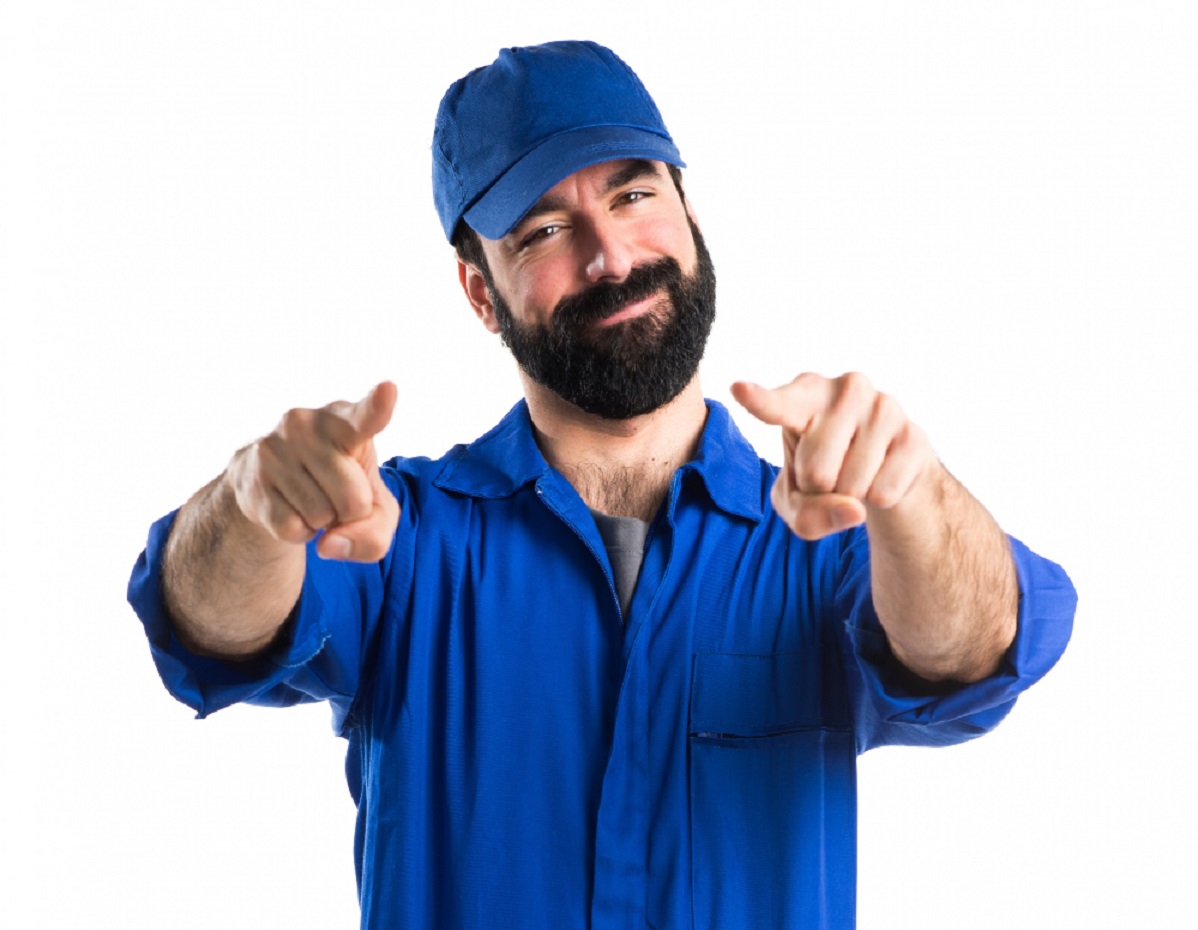 Young man with beard is smiling and pointing at front.