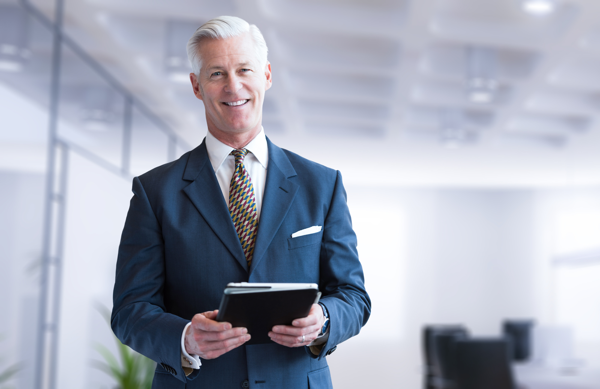 Portrait of senior businessman using tablet in front of his modern office